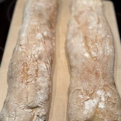 Zwei selbstgebackene Baguettes auf einem Holzbrett