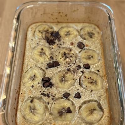 Auflaufform mit gebackenen Haferflocken, Bananenscheiben und Schokostückchen