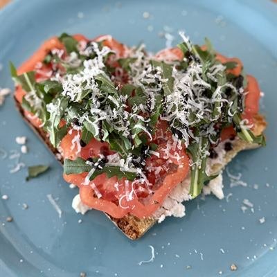 Brot mit Ricotta, Tomatenscheiben, Rucola und Parmesan
