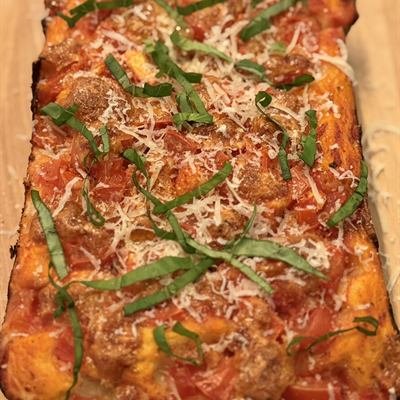 Rechteckige Focaccia-Pizza mit Tomatensoße, Käse und Basilikum