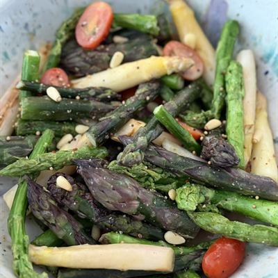 Grüner, weißer und violetter Spargel mit Cocktailtomaten und Pinienkernen