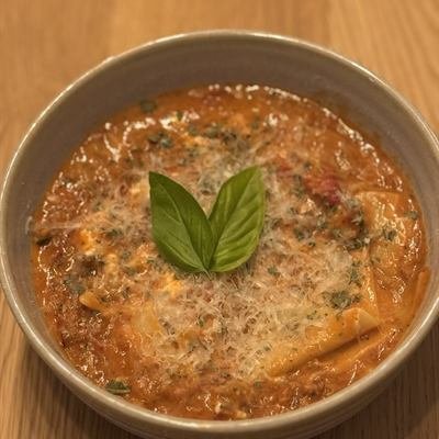 Lasagne-Suppe mit Tomaten und einem Basilikumblatt